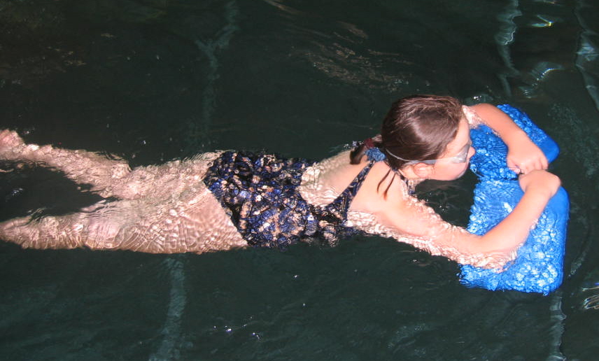 teaching a child to swim with floats